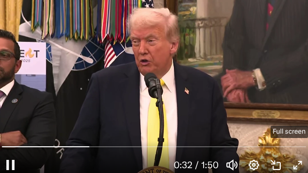 Man speaking at podium during formal event in decorated room