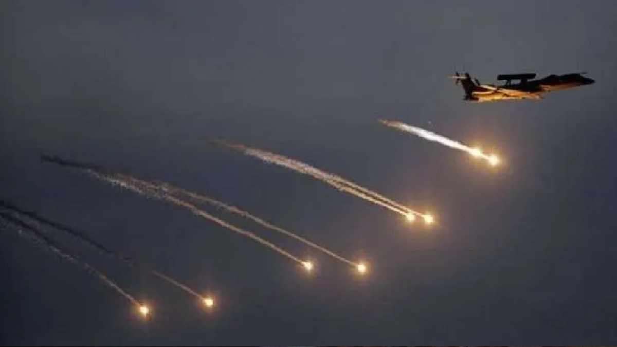 Military jet releasing flares during night training exercise.