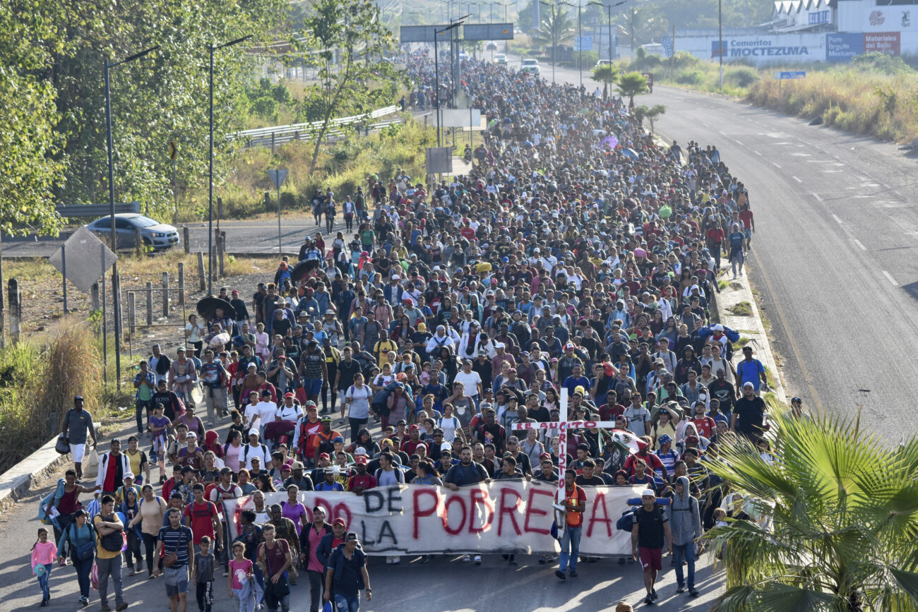 Large crowd marching on a road during a protest movement.